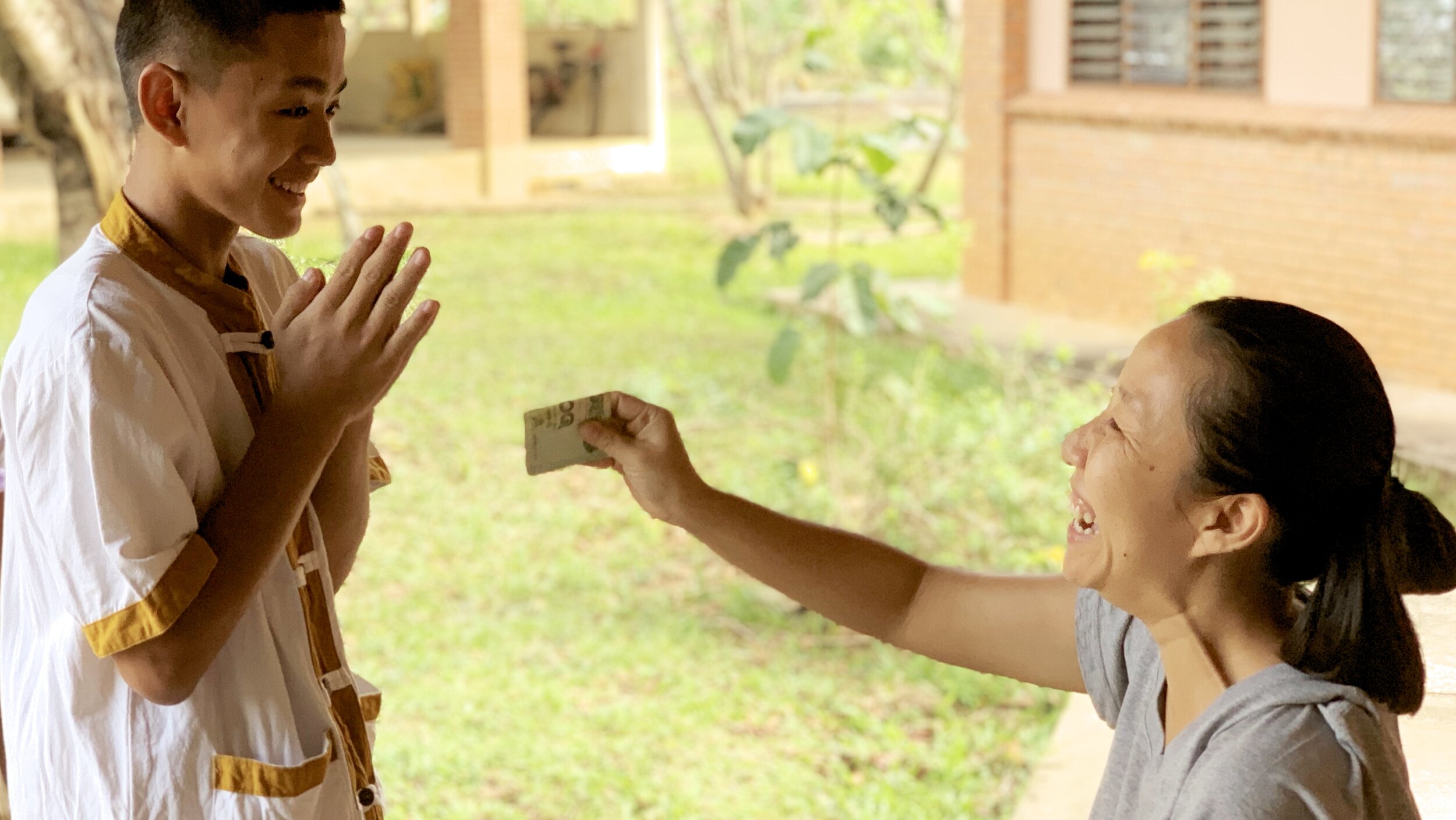Student at INFire’s program receiving money for school in Northern Thailand.